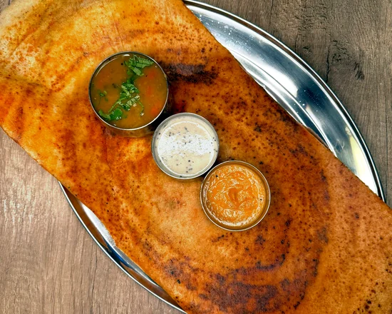 Masala dosa with sambar and two chutneys on a steel plate