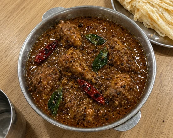 Chettinad chicken curry with dried red chillies and curry leaves, parotta on the side
