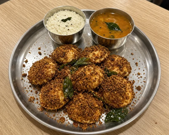 Podi idli with spice powder, sambar and coconut chutney on a steel plate