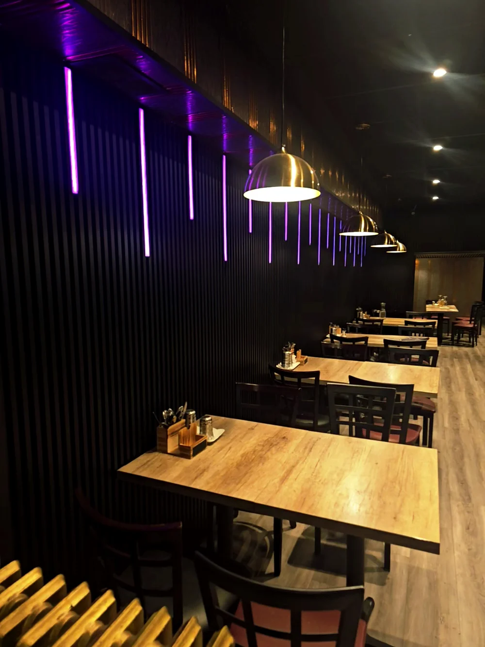 Dining room with wooden tables and purple accent lights